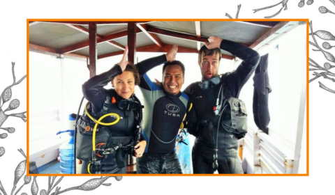 Divers on a boat make the signal for seeing a shark underwater.